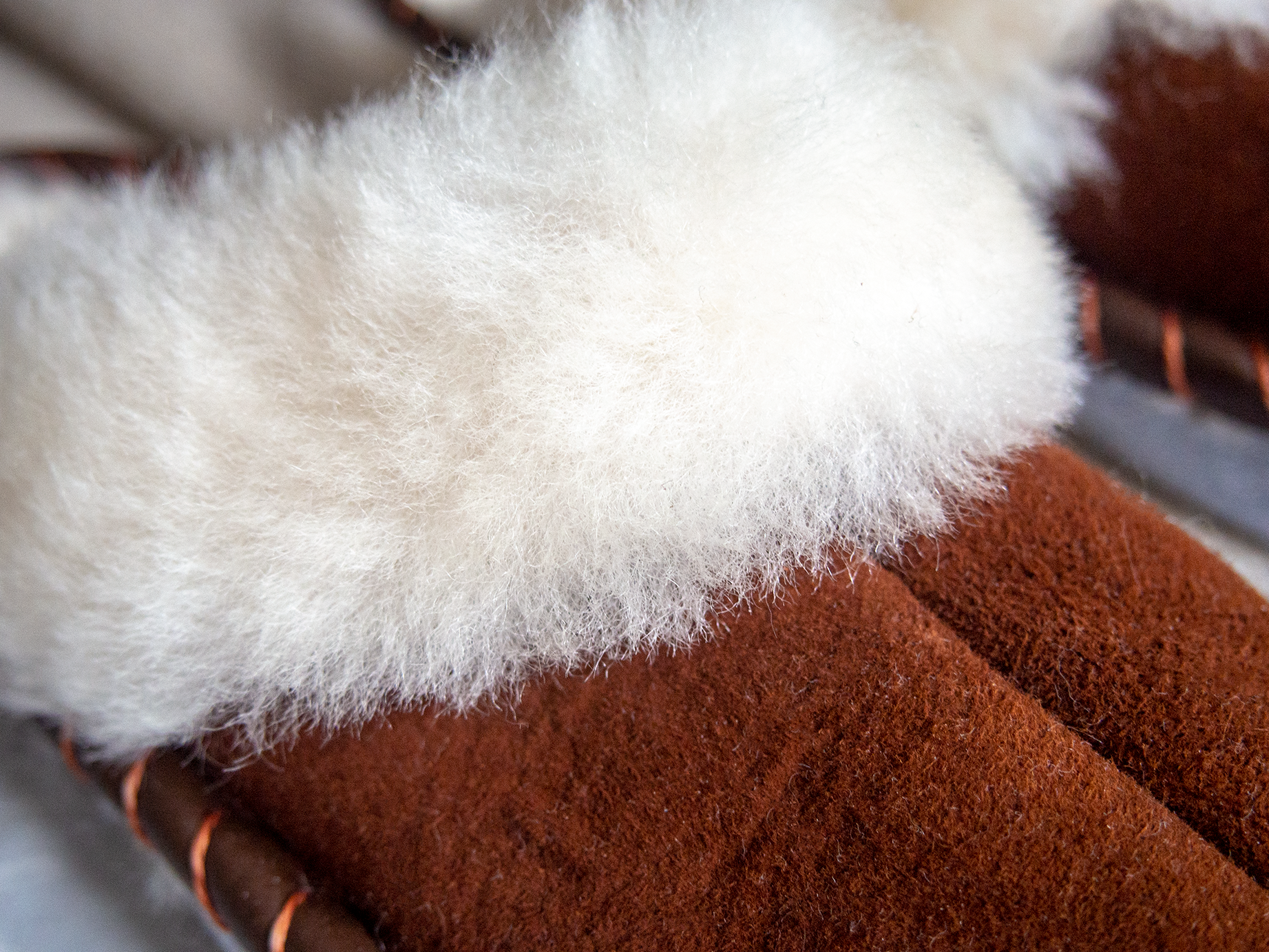 A pair of elegant brown shearling sheepskin mules, showcasing their soft texture and genuine leather detailing, perfect for comfortable wear.