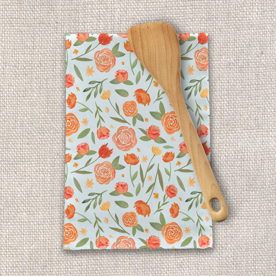 Burnt orange floral tea towel featuring a vibrant floral pattern on a cotton twill fabric, perfect for kitchen use.