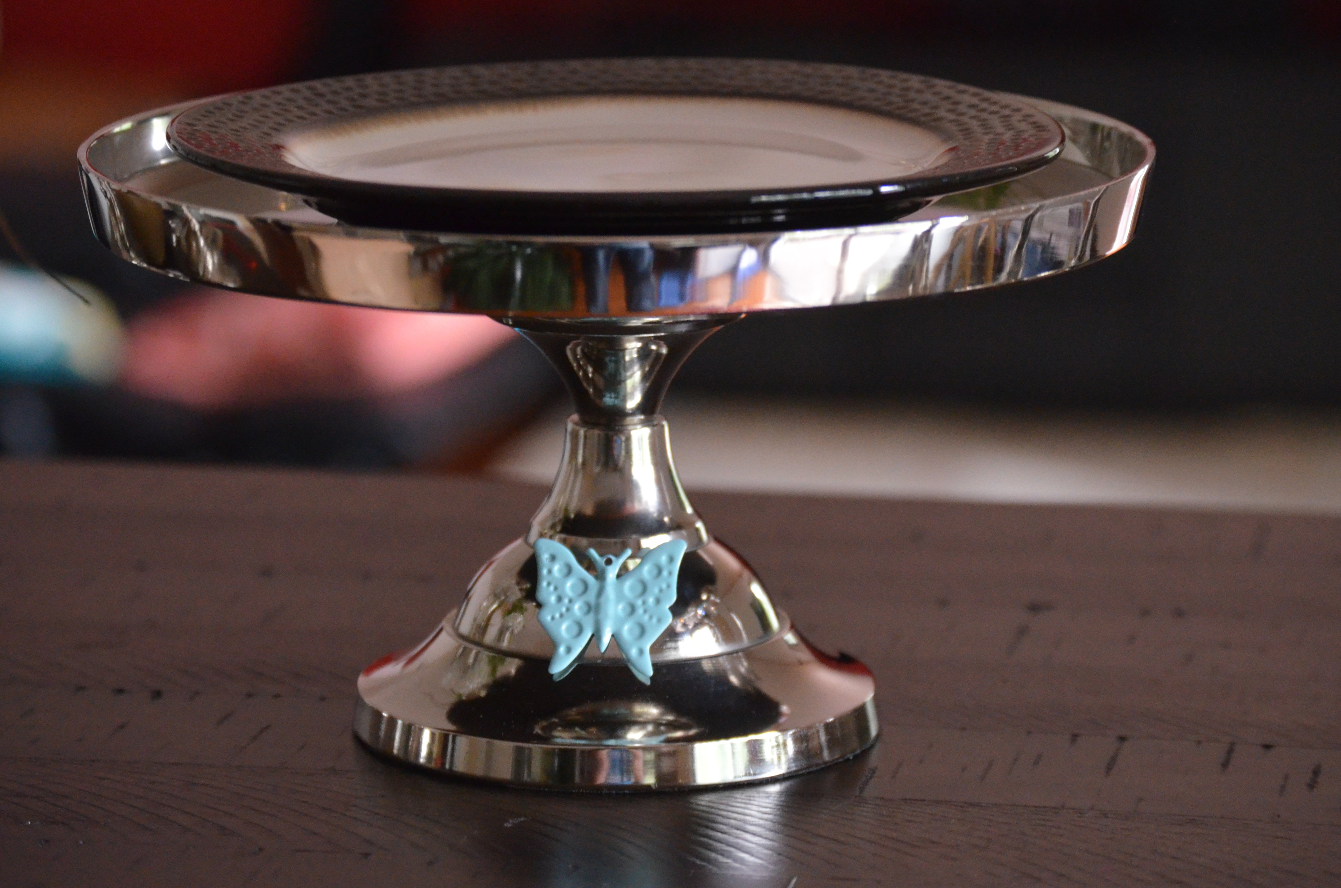 Elegant 10-inch cake stand featuring a turquoise butterfly design, handcrafted from aluminum with a silver finish, perfect for displaying cakes and desserts.