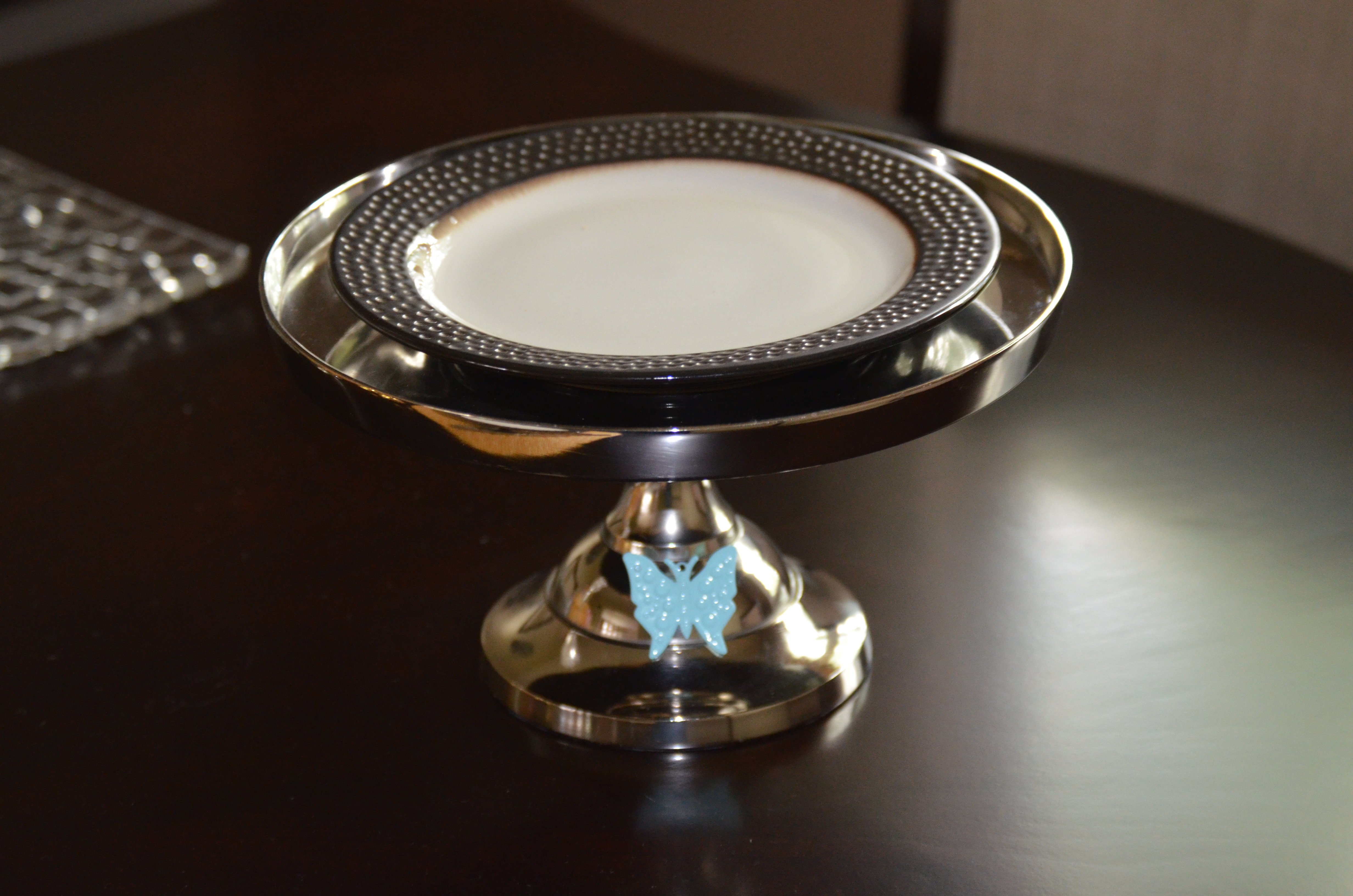 Elegant 10-inch cake stand featuring a turquoise butterfly design, handcrafted from aluminum with a silver finish, perfect for displaying cakes and desserts.