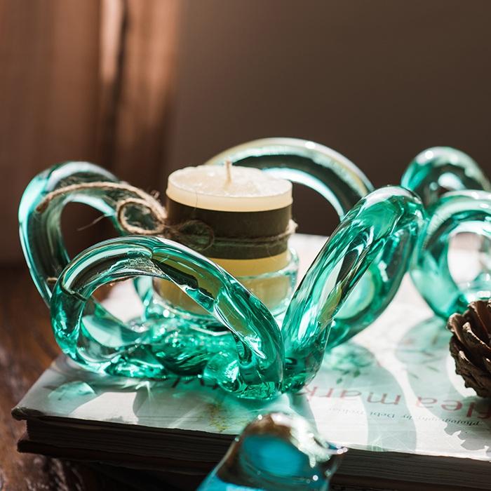 Hand blown glass candle holder in green with Qingtan flower design, showcasing unique craftsmanship and elegant shape.