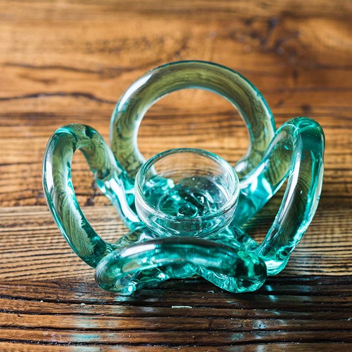 Hand blown glass candle holder in green with Qingtan flower design, showcasing unique craftsmanship and elegant shape.