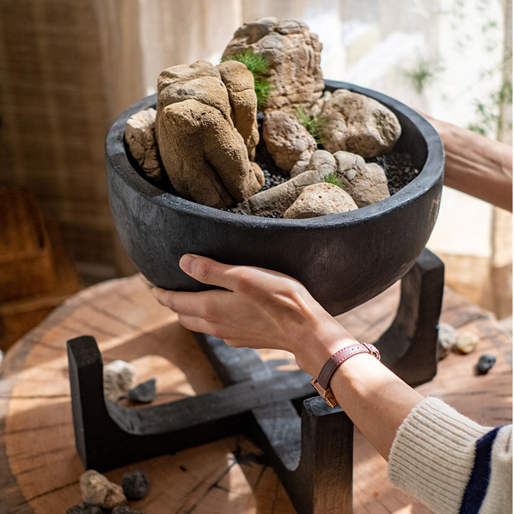 Carbonized wood plant bowl with stand, featuring a dark ashen black finish and minimalist design, ideal for decorative arrangements.