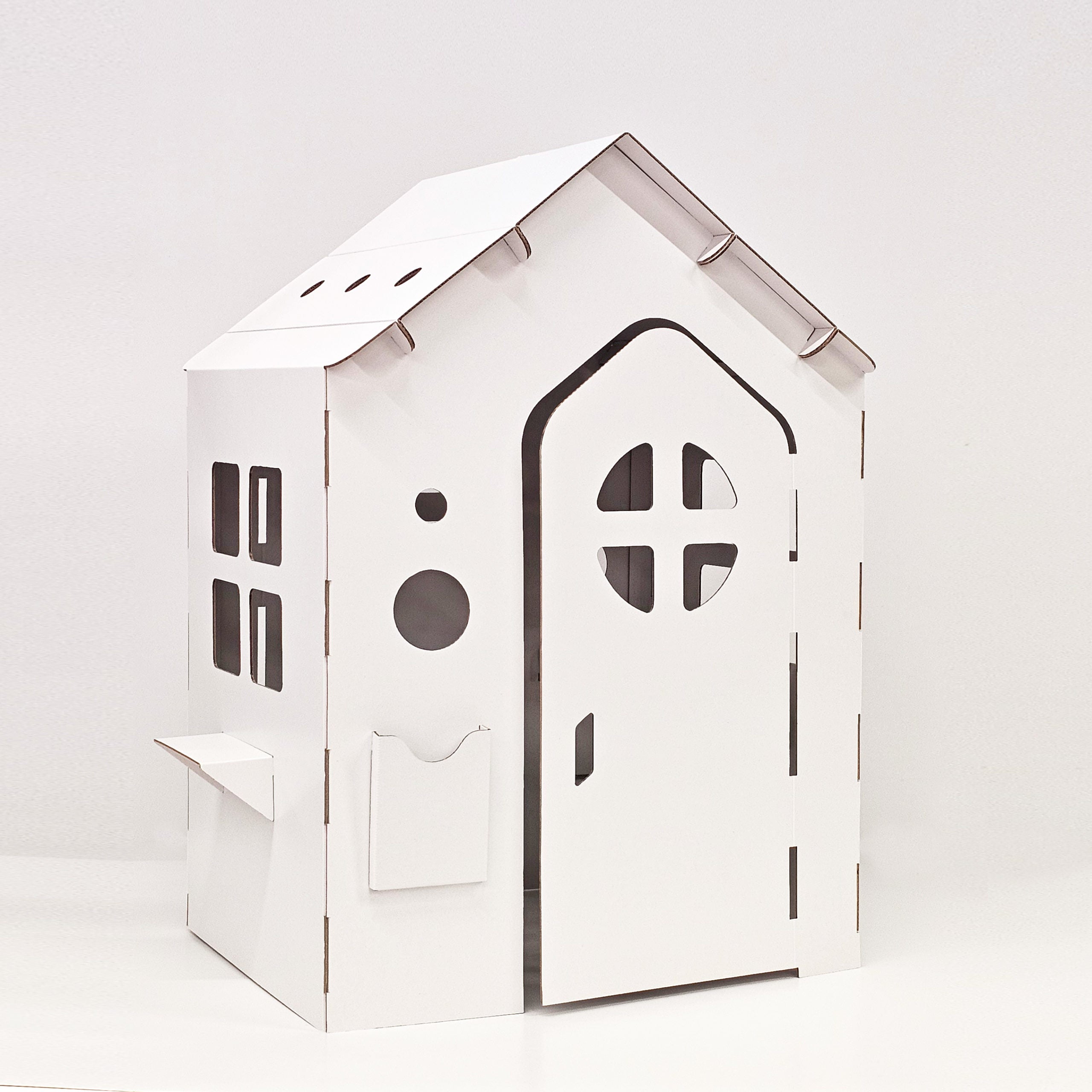 Cardboard playhouse WONDERLAND in white, featuring doors, windows, and a mailbox, designed for children's imaginative play.