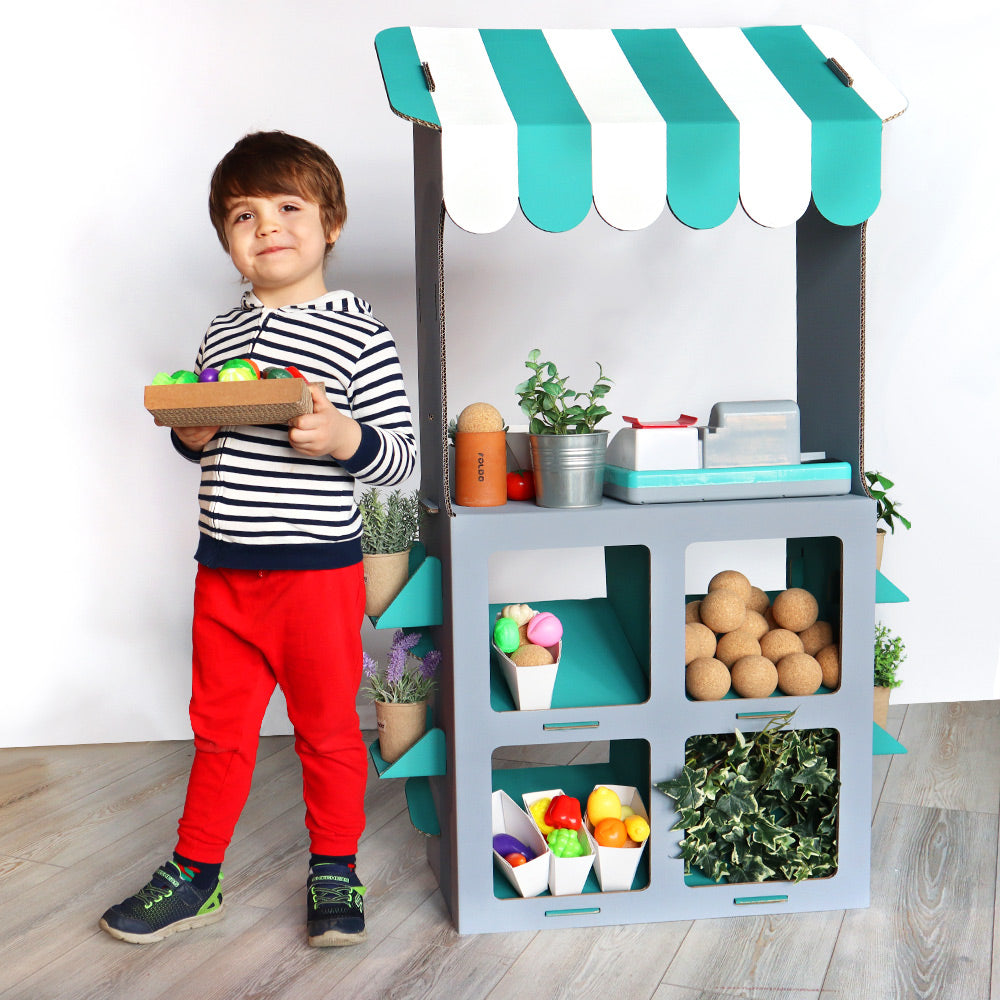 A colorful cardboard stand for kids featuring an awning and poles, designed for imaginative play and entrepreneurship.