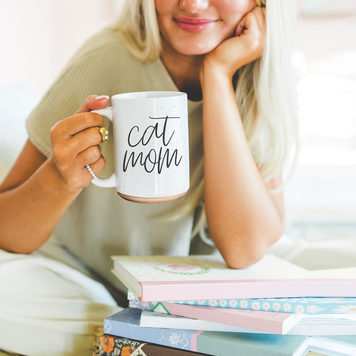 A stylish off-white ceramic mug with dark speckles, featuring a black graphic that reads 'Cat Mom' on both sides, perfect for cat lovers.