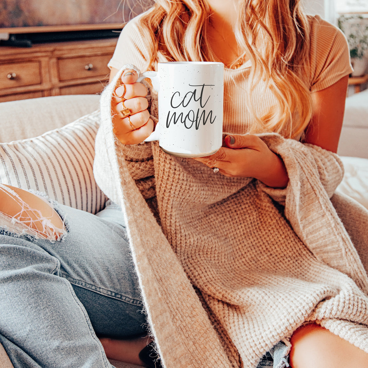 A stylish off-white ceramic mug with dark speckles, featuring a black graphic that reads 'Cat Mom' on both sides, perfect for cat lovers.