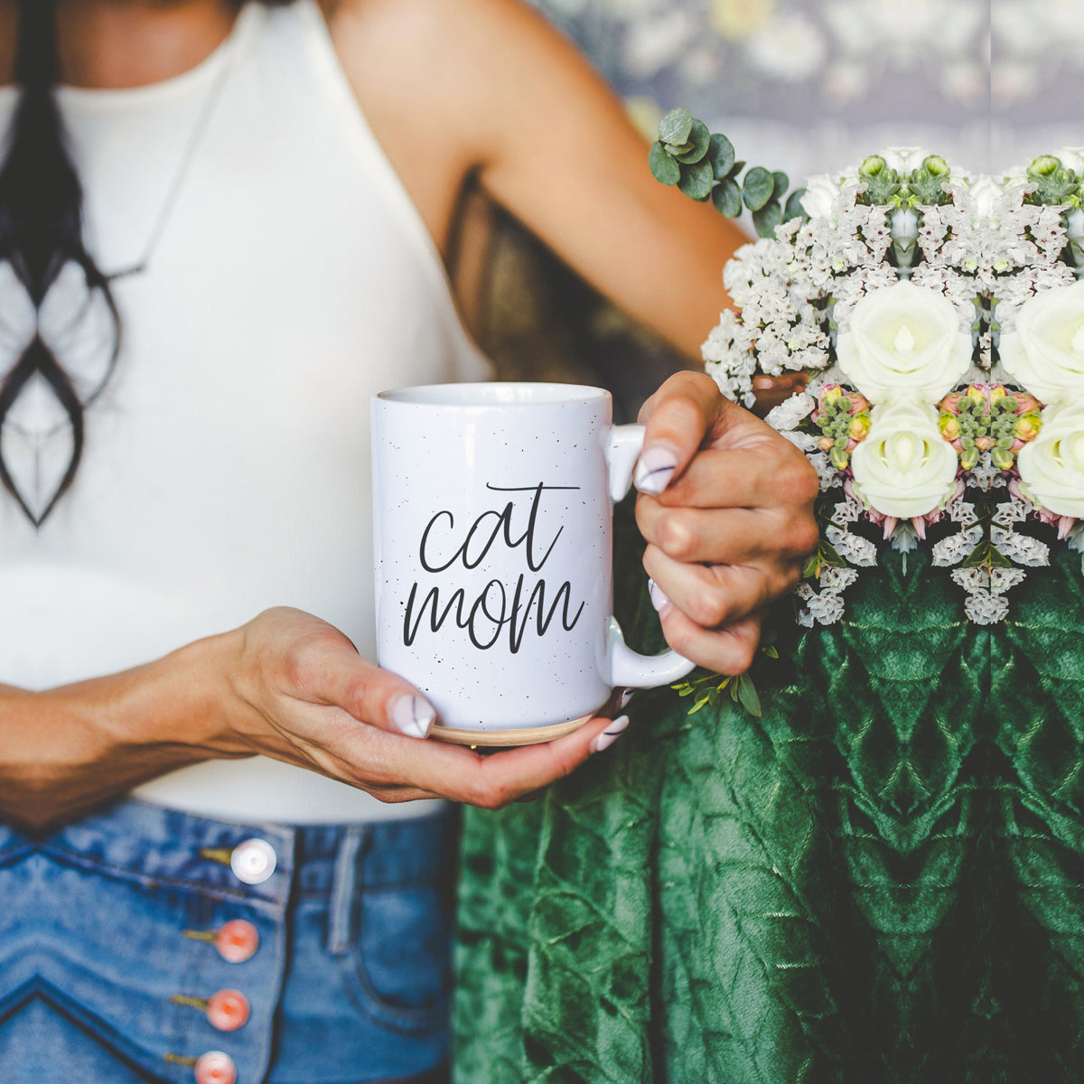 A stylish off-white ceramic mug with dark speckles, featuring a black graphic that reads 'Cat Mom' on both sides, perfect for cat lovers.