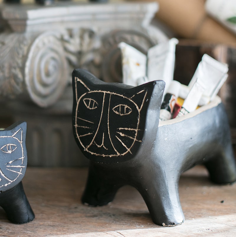 A charming cat-shaped small planter made of concrete, showcasing a unique design in black, khaki, and mixed colors.