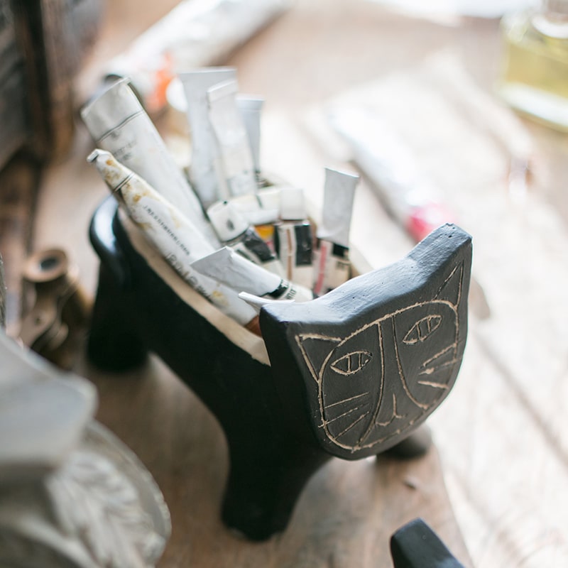 A charming cat-shaped small planter made of concrete, showcasing a unique design in black, khaki, and mixed colors.