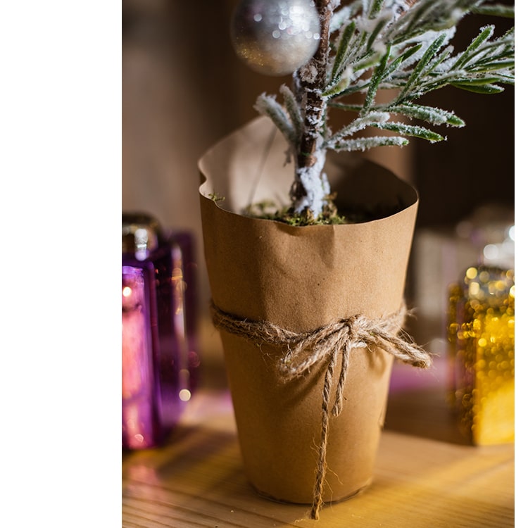 Cedar Fir Tree Snow Flocked Christmas Tree with a paper wrapped base, showcasing realistic snow and green foliage.