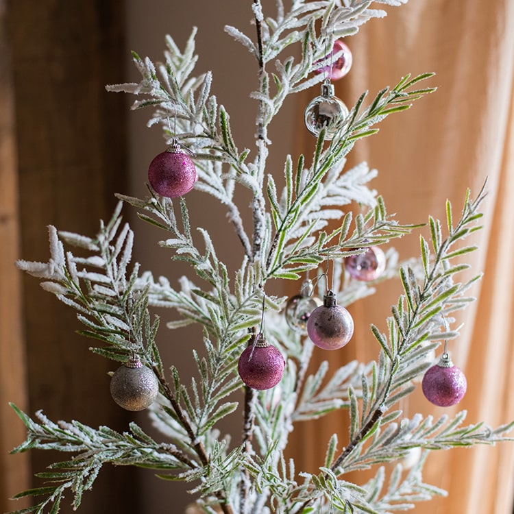 Cedar Fir Tree Snow Flocked Christmas Tree with a paper wrapped base, showcasing realistic snow and green foliage.