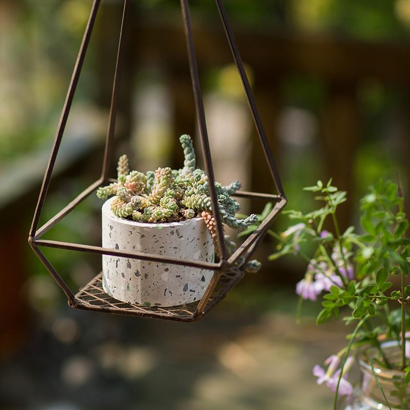 A collection of cement planters in various shapes, colors, and sizes, showcasing their modern design and durable material.