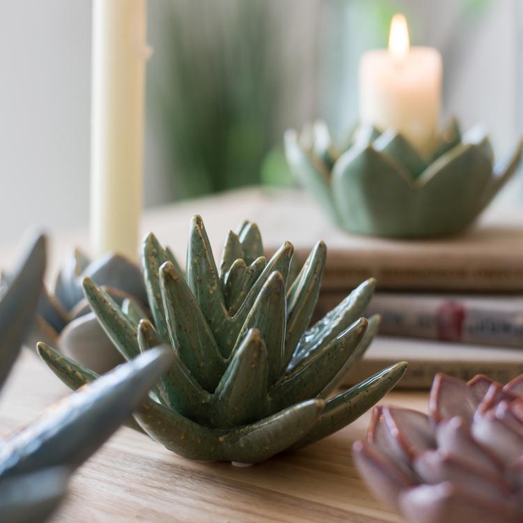 A collection of handmade ceramic floral table accents in various colors and sizes, showcasing their unique designs.