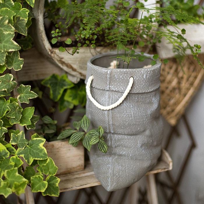 Ceramic planter with linen bag design in green and gray, showcasing its elegant shape and texture.