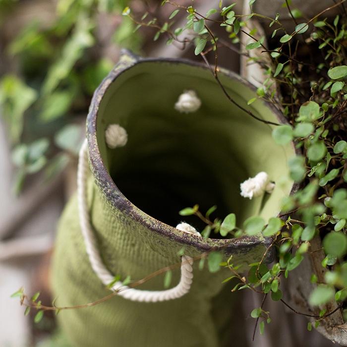 Ceramic planter with linen bag design in green and gray, showcasing its elegant shape and texture.