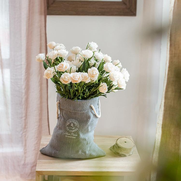 Ceramic planter with linen bag design in green and gray, showcasing its elegant shape and texture.