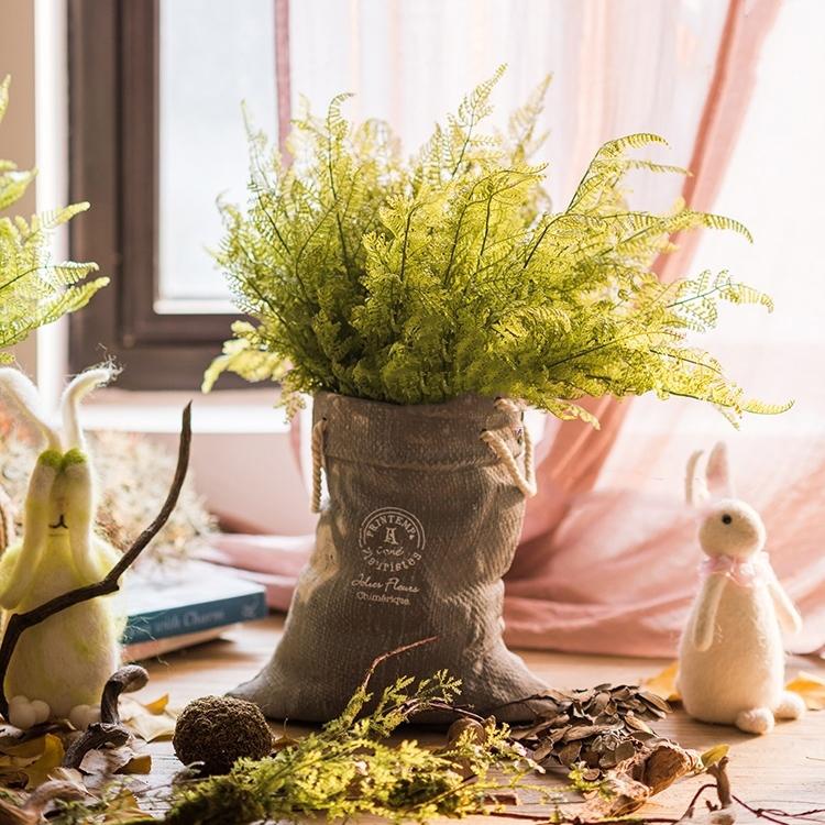 Ceramic planter with linen bag design in green and gray, showcasing its elegant shape and texture.