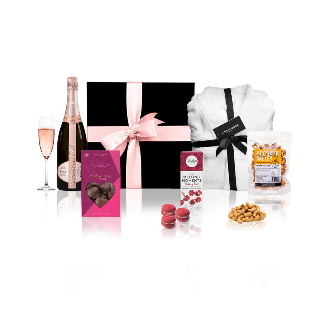 Chandon & Linenhouse Gift Hamper featuring sparkling wine, bathrobe, chocolates, and nuts in a stylish black box with a pink bow.