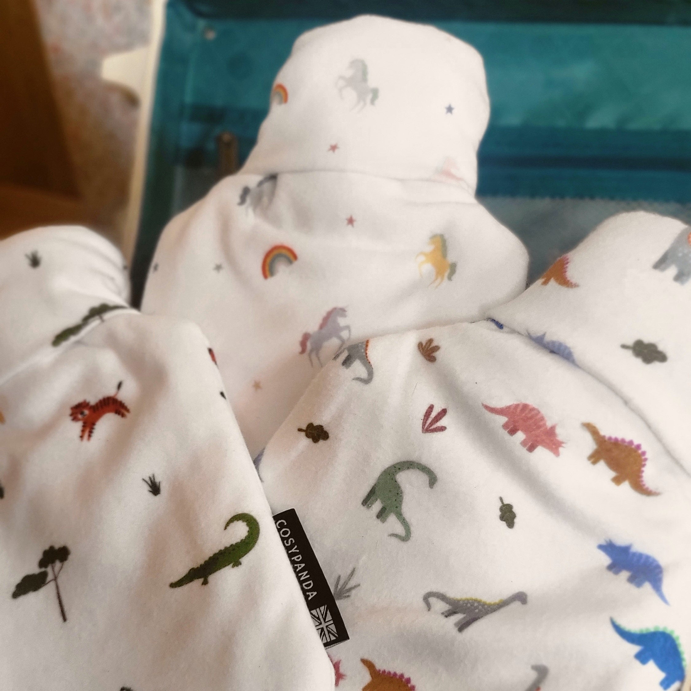 A soft children's hot water bottle featuring a colorful unicorn rainbow print, designed for comfort and safety.