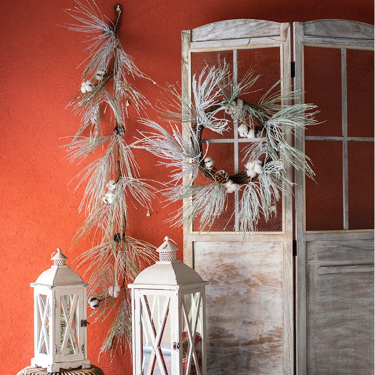 A beautifully crafted Christmas Faux Snow Pine Needle Wreath made from natural rattan, adorned with pine cones and cotton, showcasing a wintery aesthetic.