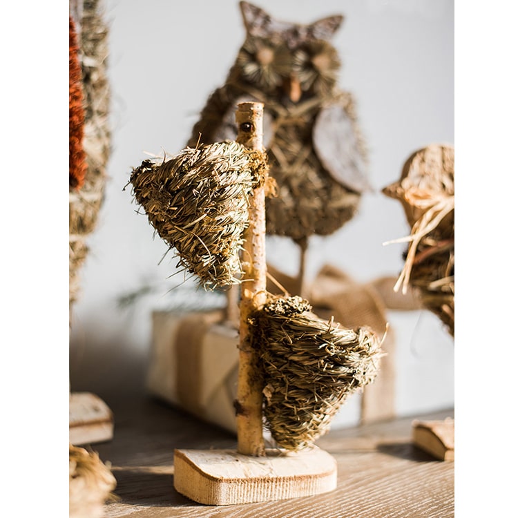 A collection of rustic Christmas figurine decorations including a hen, owl, rabbit, and flowers, crafted from natural wood and straw.