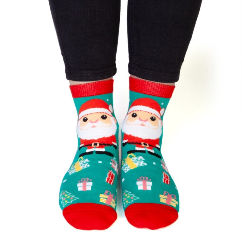 A pair of Christmas socks featuring a cheerful Santa Claus surrounded by presents and Christmas trees in vibrant red and green colors.