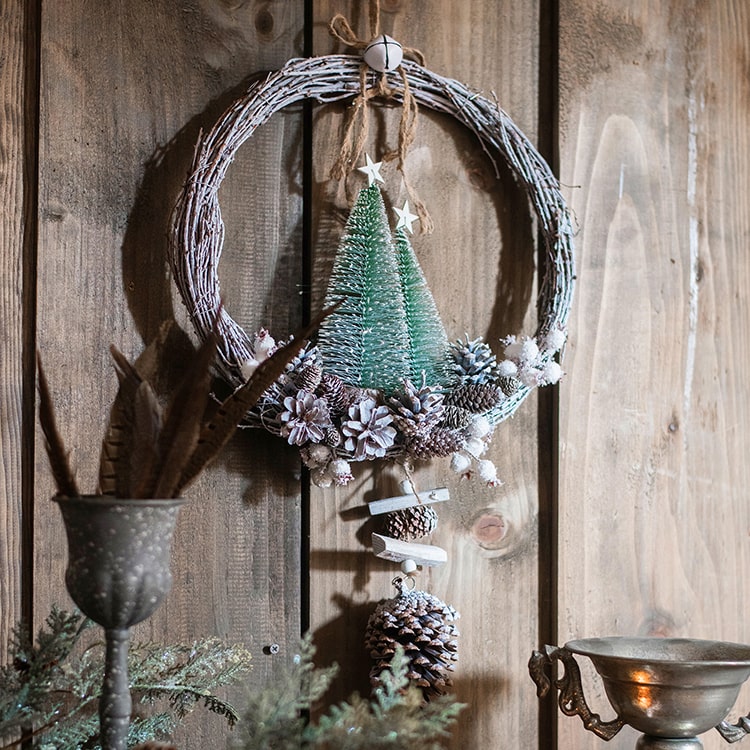 Rustic Christmas wreath made of natural rattan and pine cones, perfect for holiday decoration.