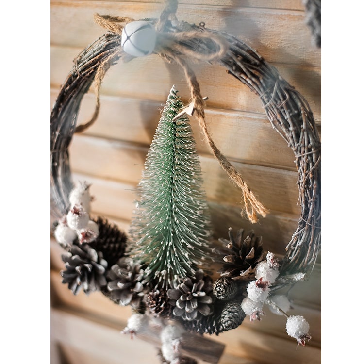 Rustic Christmas wreath made of natural rattan and pine cones, perfect for holiday decoration.