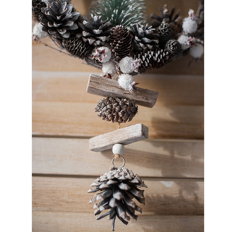 Rustic Christmas wreath made of natural rattan and pine cones, perfect for holiday decoration.