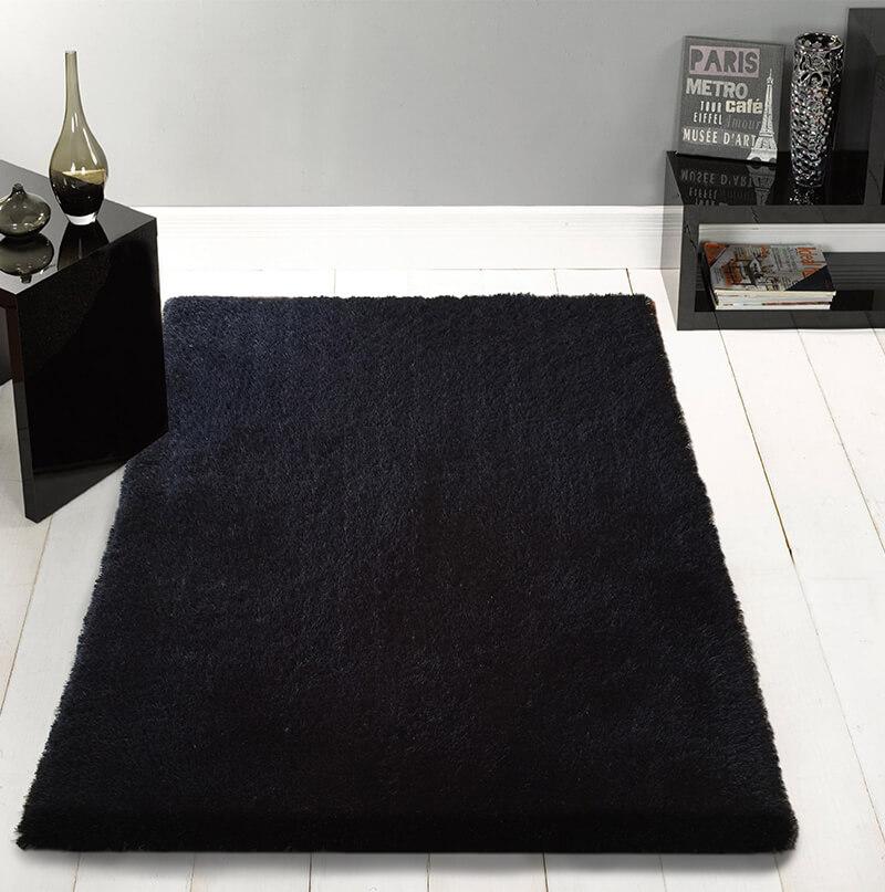 Chubby Black Area Rug featuring a soft shaggy texture, hand tufted design, and cotton backing, available in two sizes.