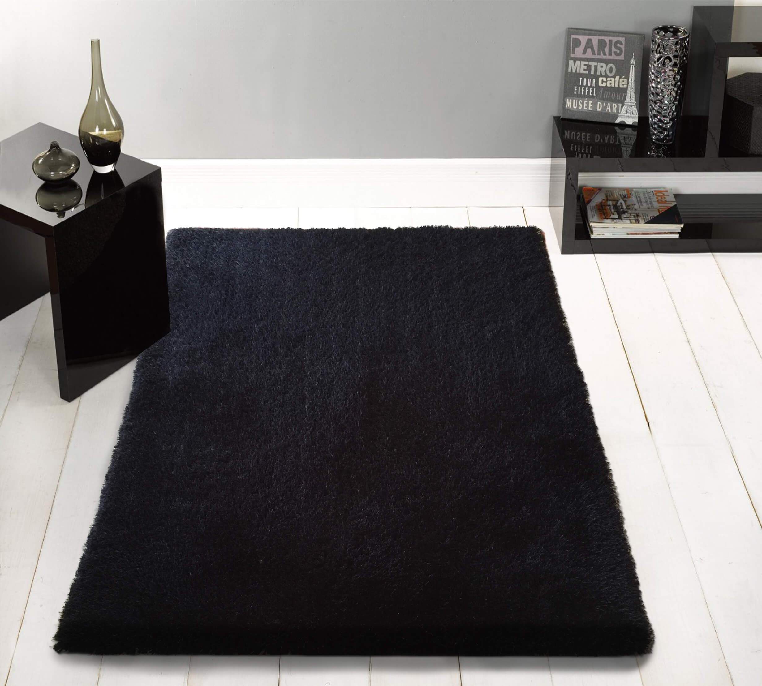 Chubby Black Area Rug featuring a soft shaggy texture, hand tufted design, and cotton backing, available in two sizes.