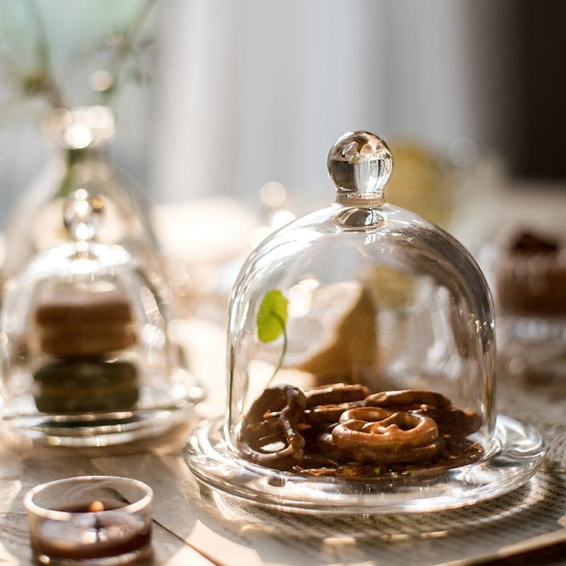 A clear glass dome showcasing a decorative item inside, elegantly designed for display purposes.