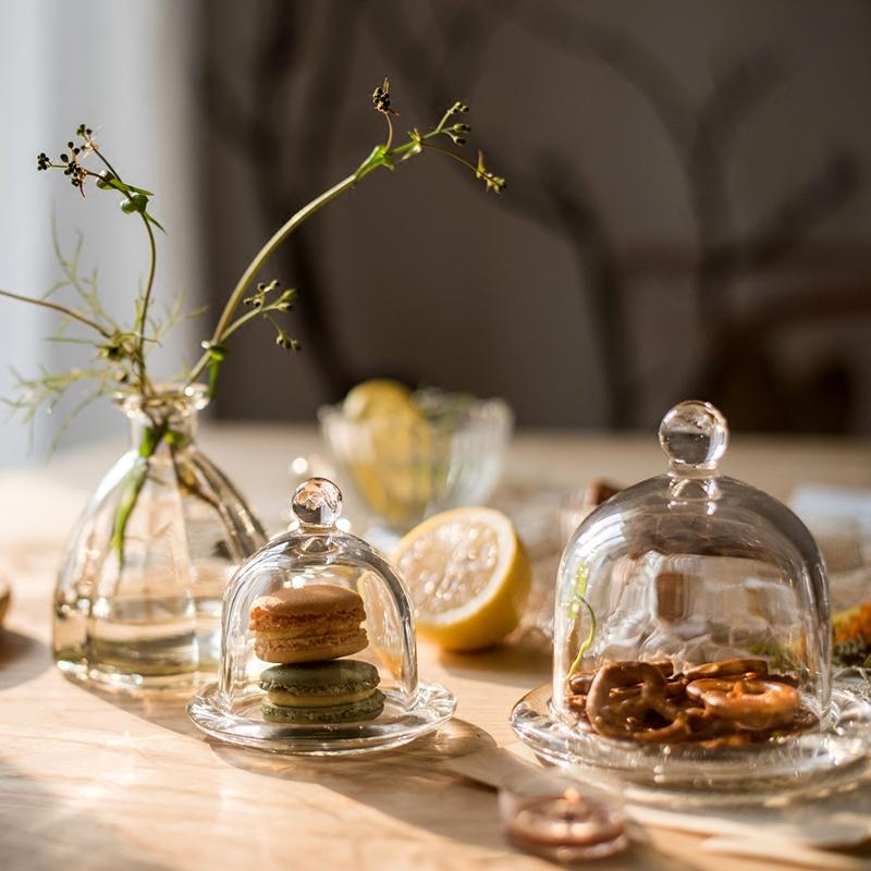 A clear glass dome showcasing a decorative item inside, elegantly designed for display purposes.