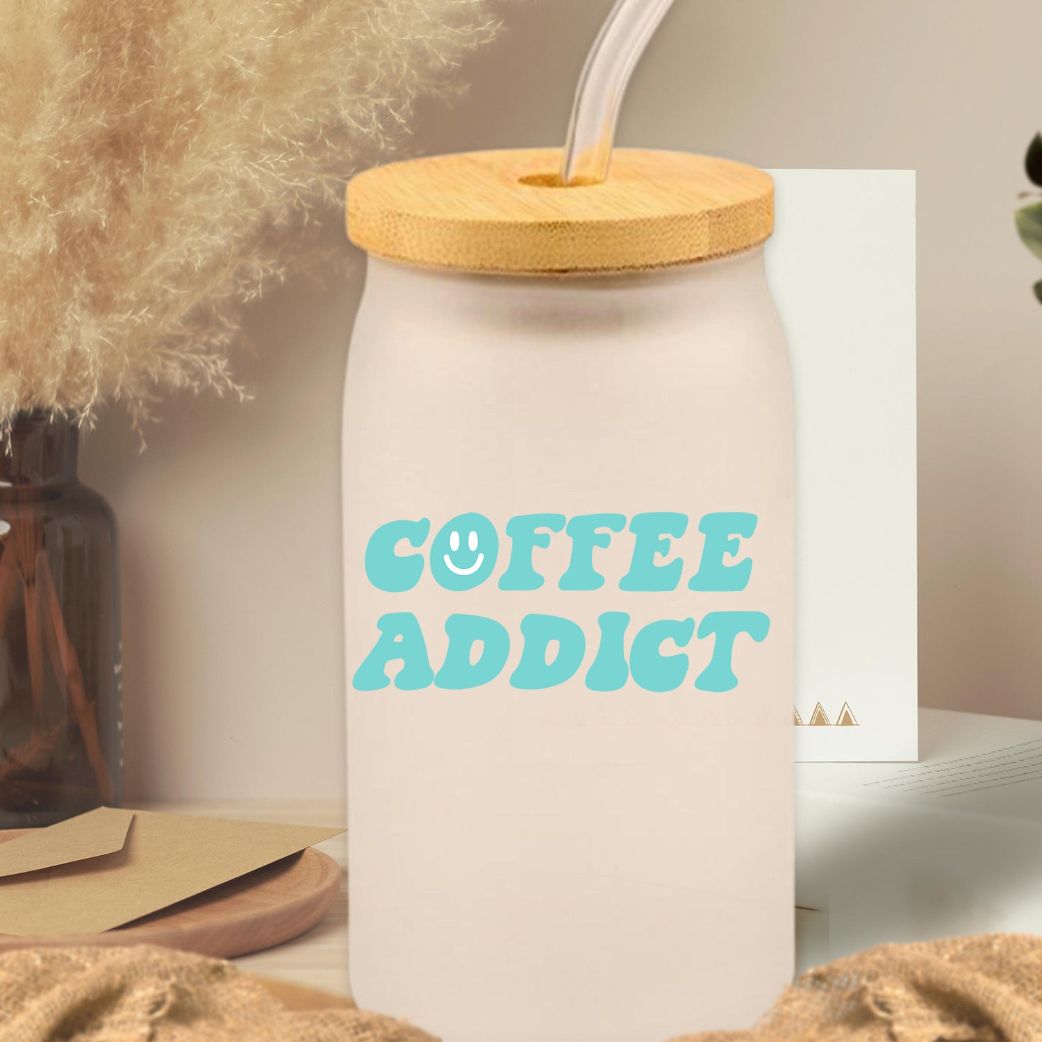 Coffee Addict Glass Can Tumbler with bamboo lid and clear straw, showcasing a frosted glass design.