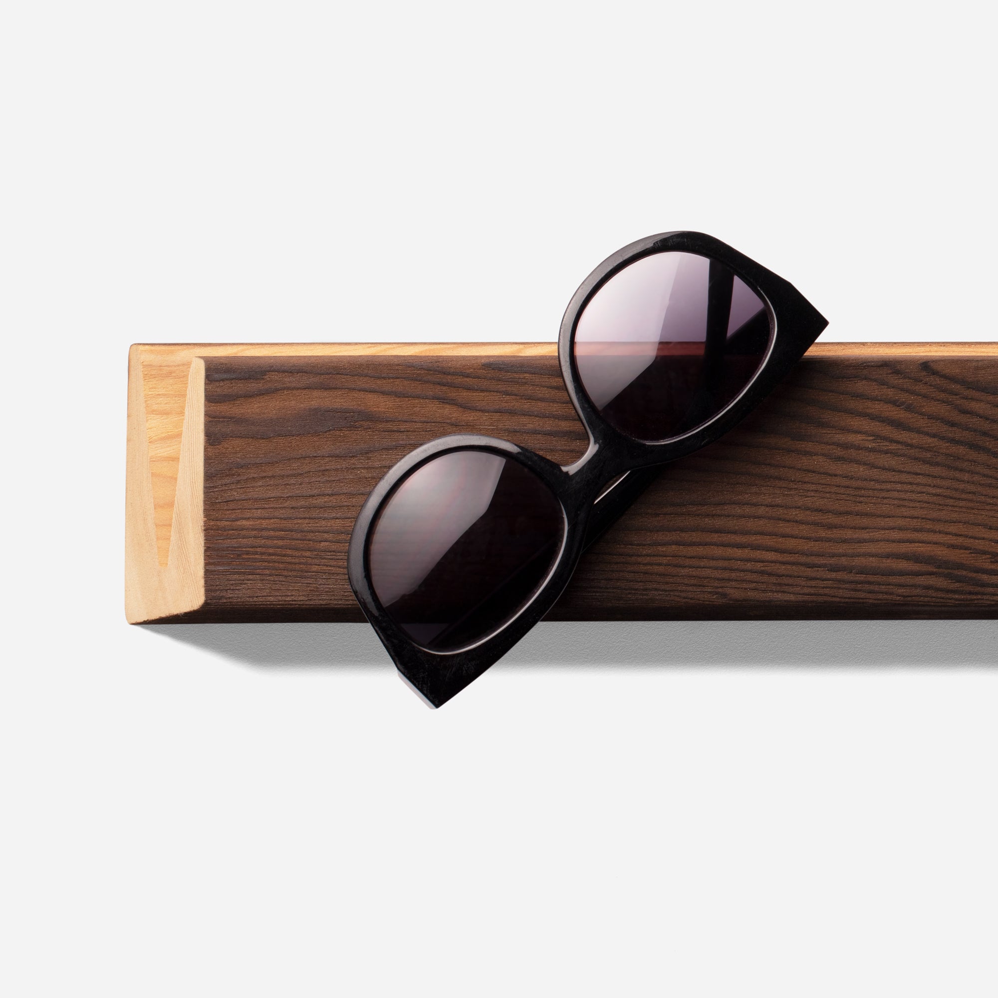 Stylish Cool sunglass holder displaying multiple sunglasses on a wall, showcasing its elegant design and natural wood finish.