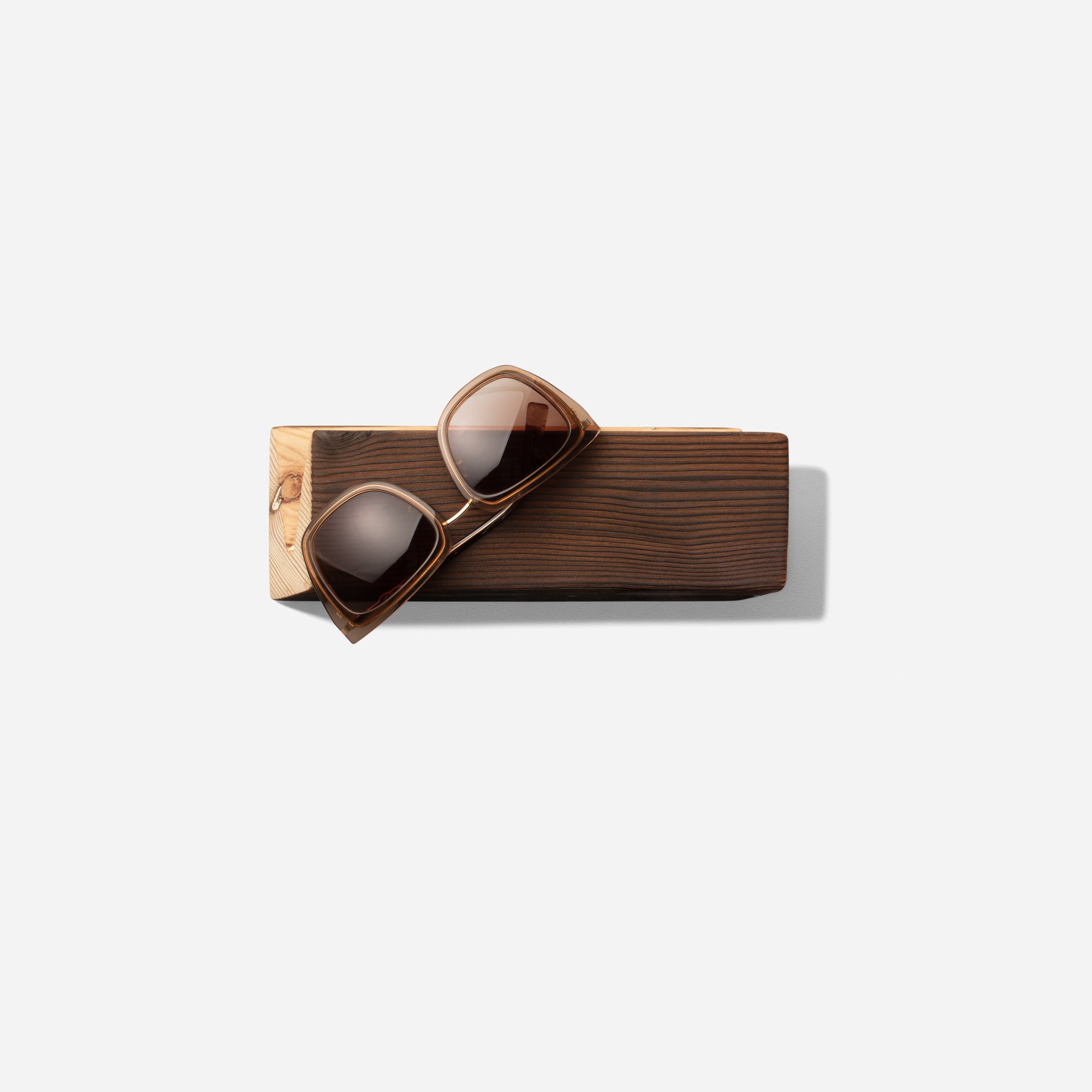 Stylish Cool sunglass holder displaying multiple sunglasses on a wall, showcasing its elegant design and natural wood finish.