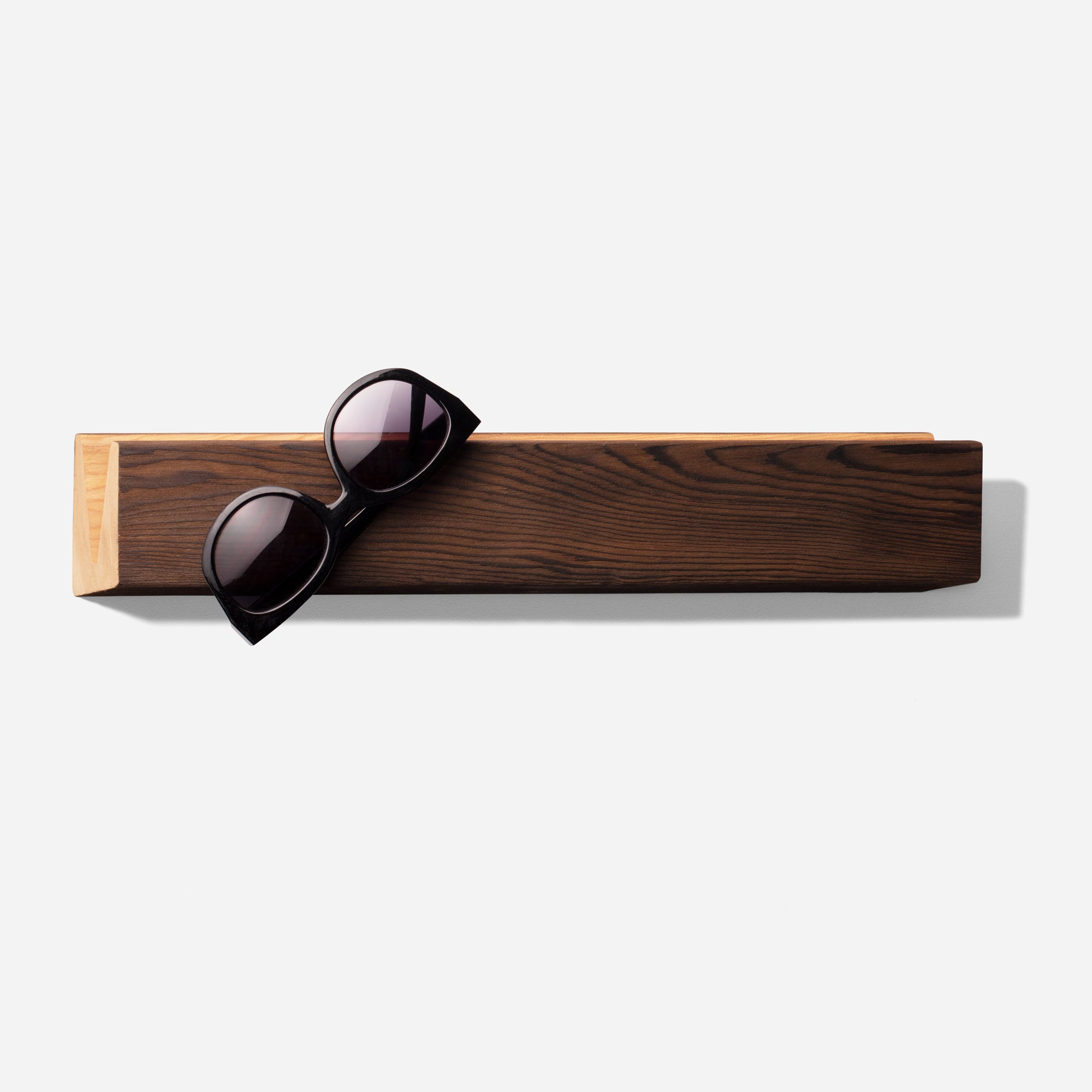 Stylish Cool sunglass holder displaying multiple sunglasses on a wall, showcasing its elegant design and natural wood finish.