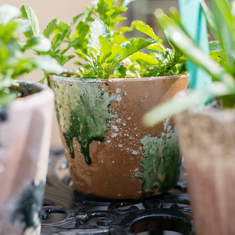 Colorful terracotta pot with vibrant mixed colors, featuring a drainage hole, ideal for plants and decoration.