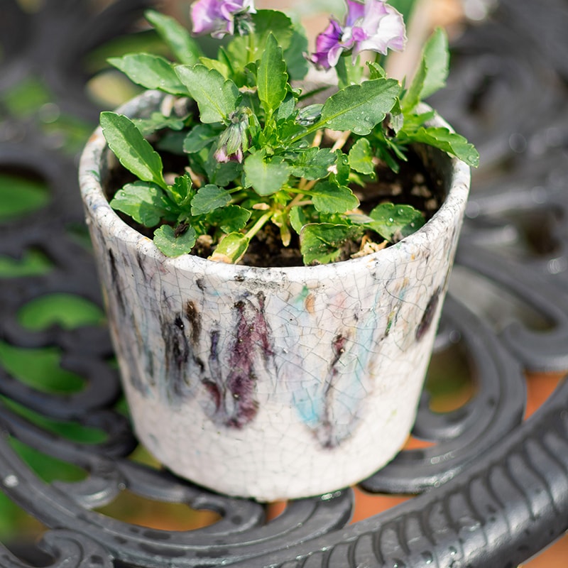 Colorful terracotta pot with vibrant mixed colors, featuring a drainage hole, ideal for plants and decoration.