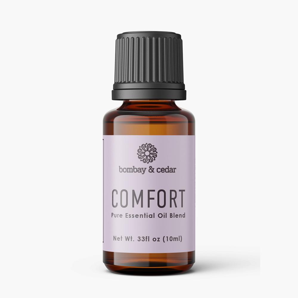 10ml bottle of Comfort Essential Oil Blend with a calming label, surrounded by natural herbs and flowers.