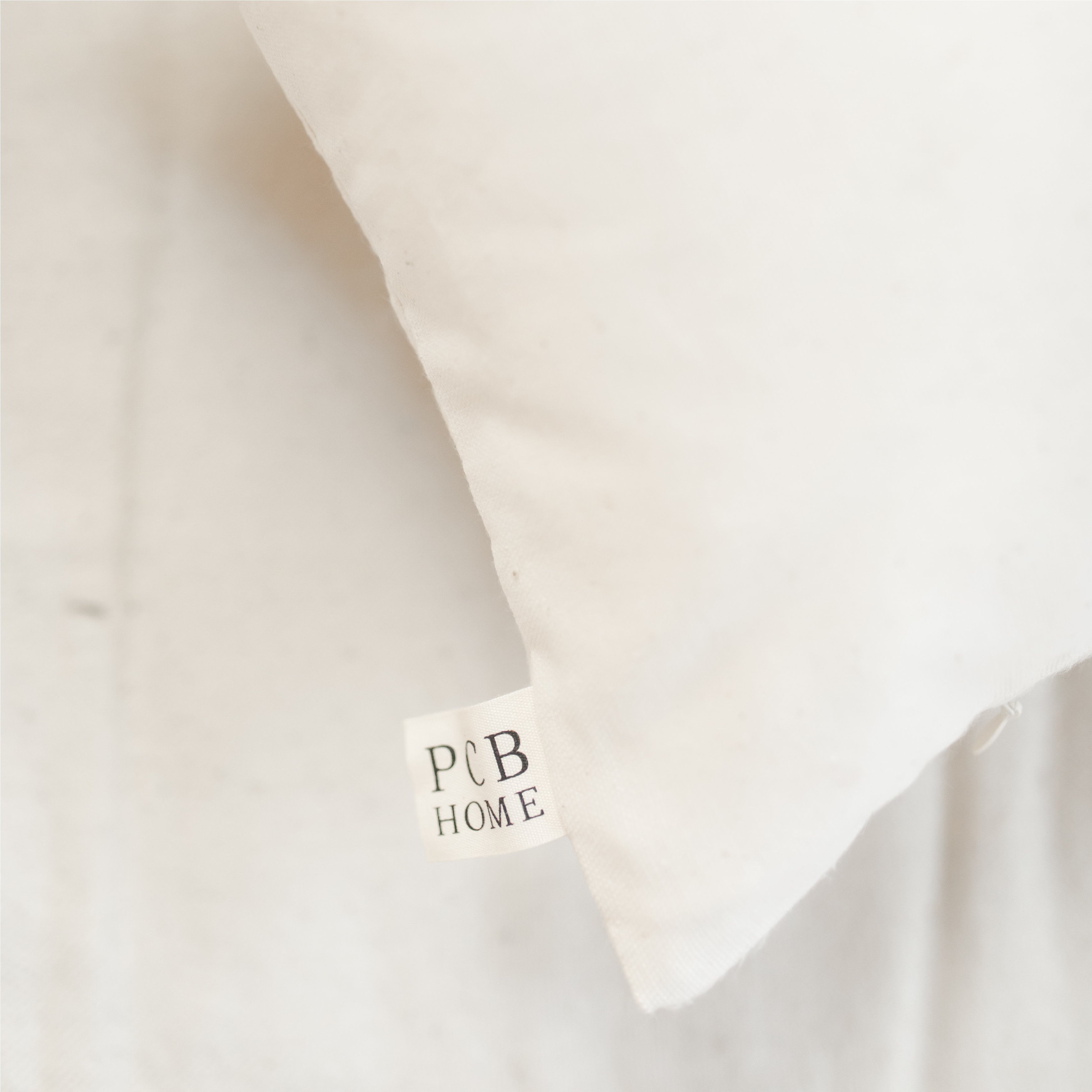 A cozy pillow with the quote 'Coming Home To You Is My Favorite Thing' in elegant calligraphy, made from 100% natural cotton fabric.