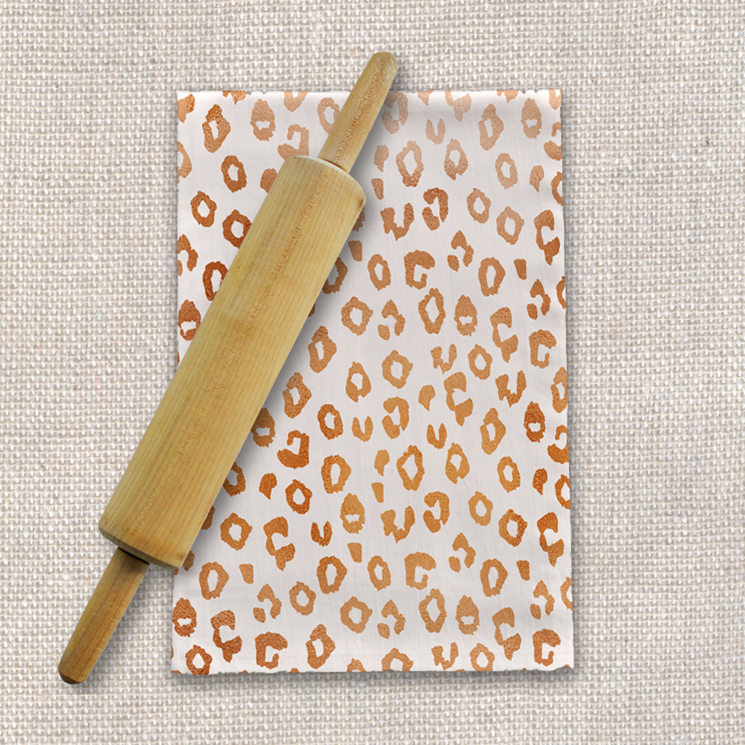 Copper leopard print tea towel made of cotton twill, featuring a stylish design and hemmed edges, perfect for kitchen use.