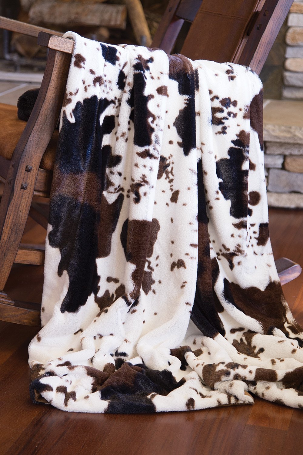 A cozy Cowhide Faux Fur Throw measuring 50" x 60", featuring a luxurious faux fur texture and stylish cowhide pattern.