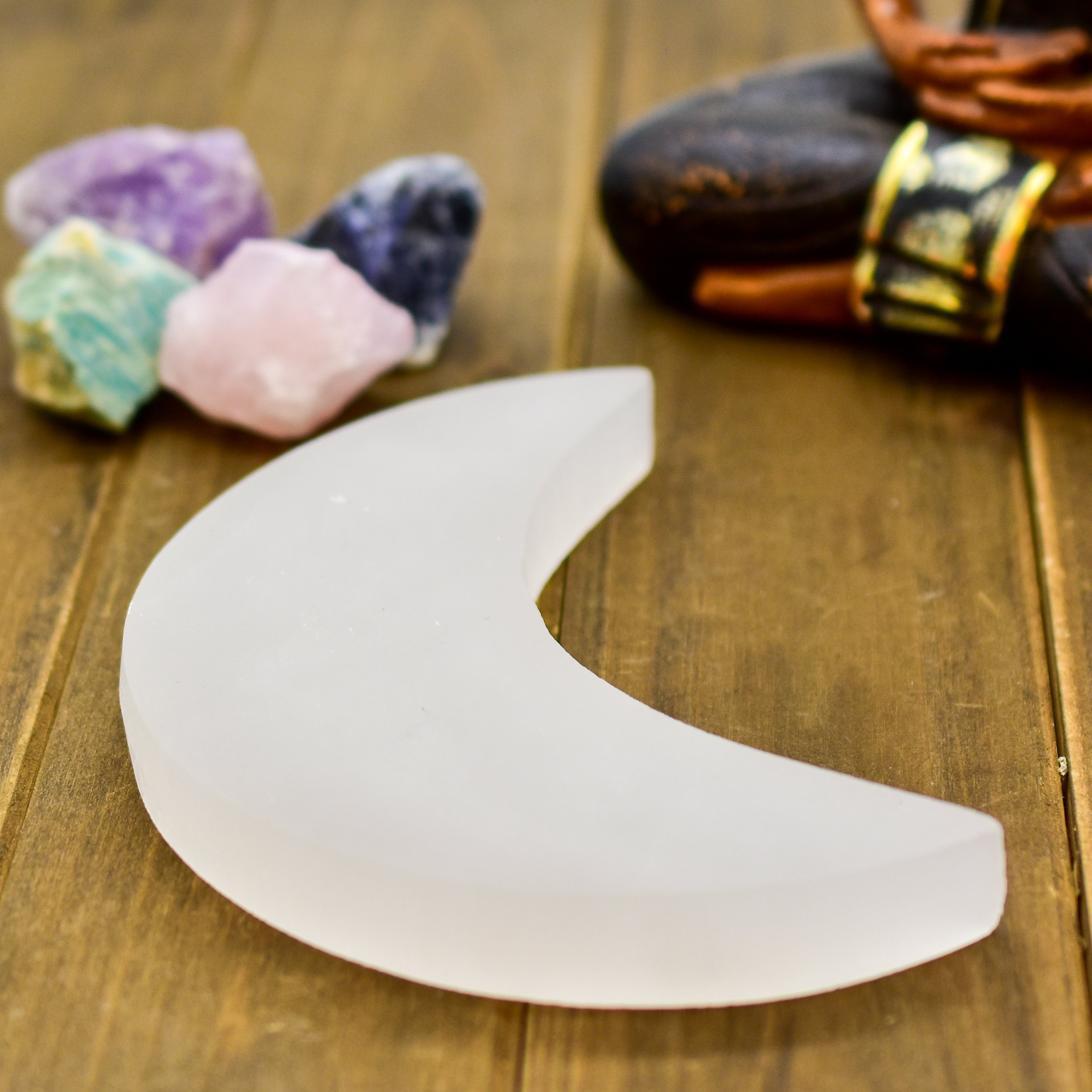 Crescent Moon Selenite Charging Plate, handcarved in Morocco, showcasing its delicate crescent shape and polished surface.