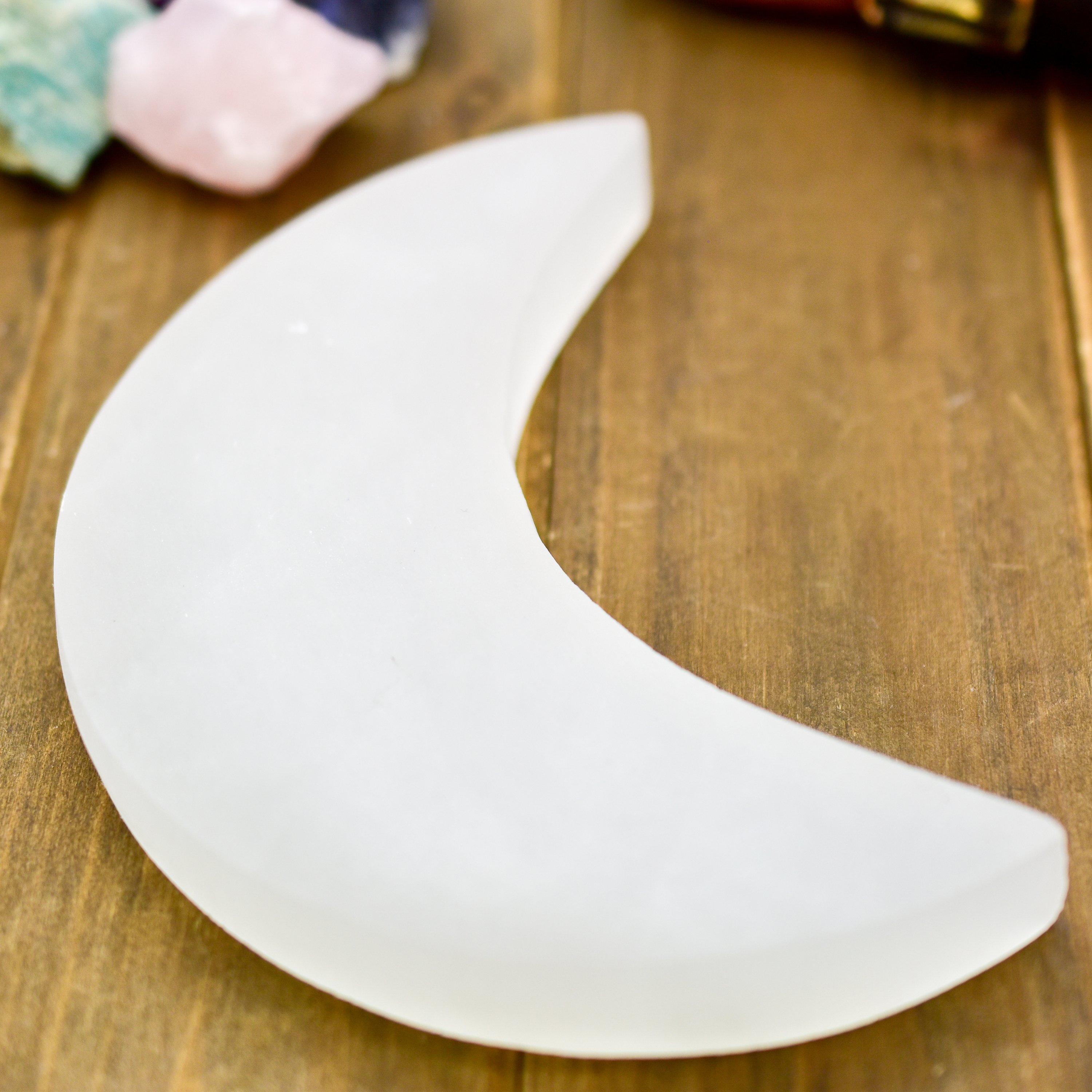 Crescent Moon Selenite Charging Plate, handcarved in Morocco, showcasing its delicate crescent shape and polished surface.