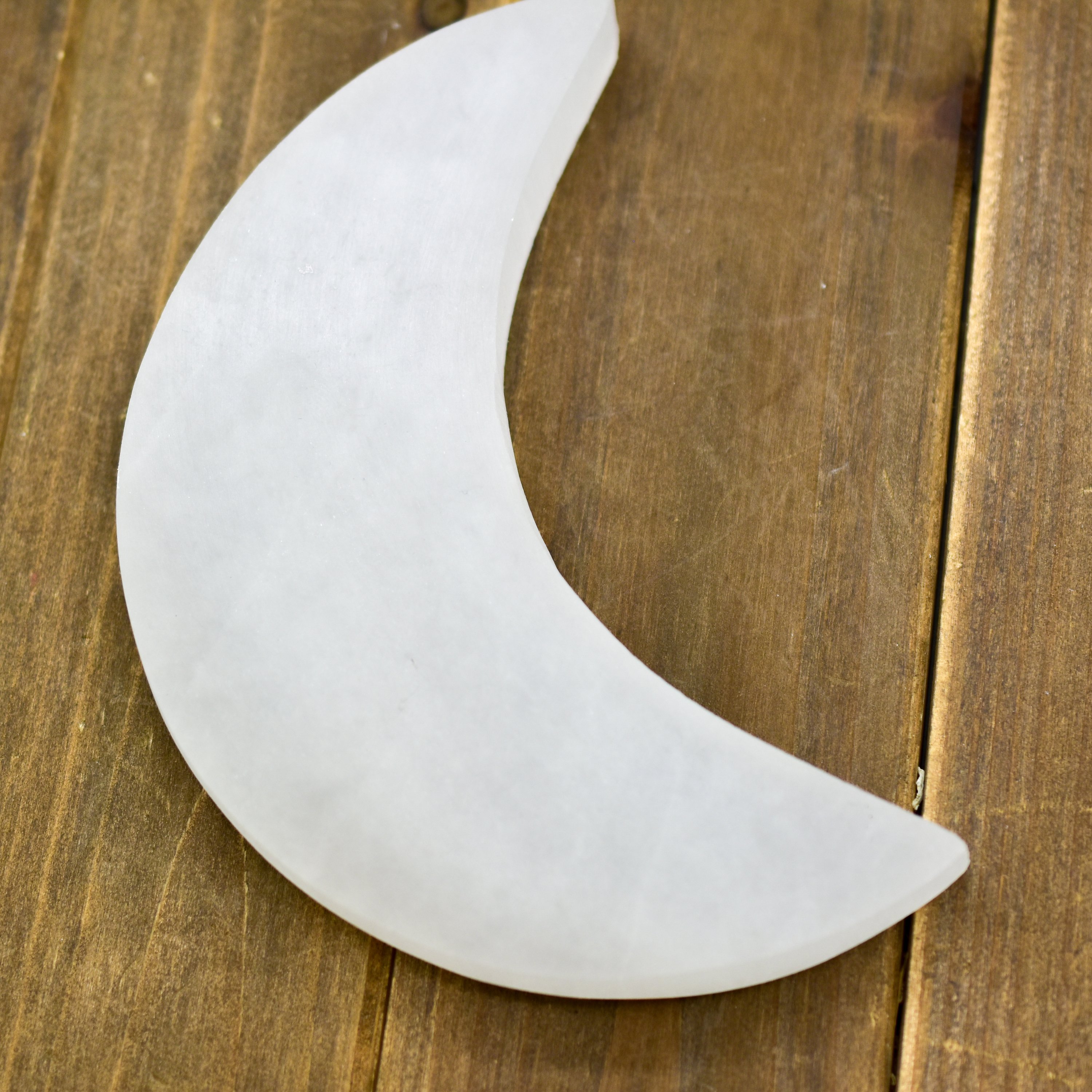 Crescent Moon Selenite Charging Plate, handcarved in Morocco, showcasing its delicate crescent shape and polished surface.