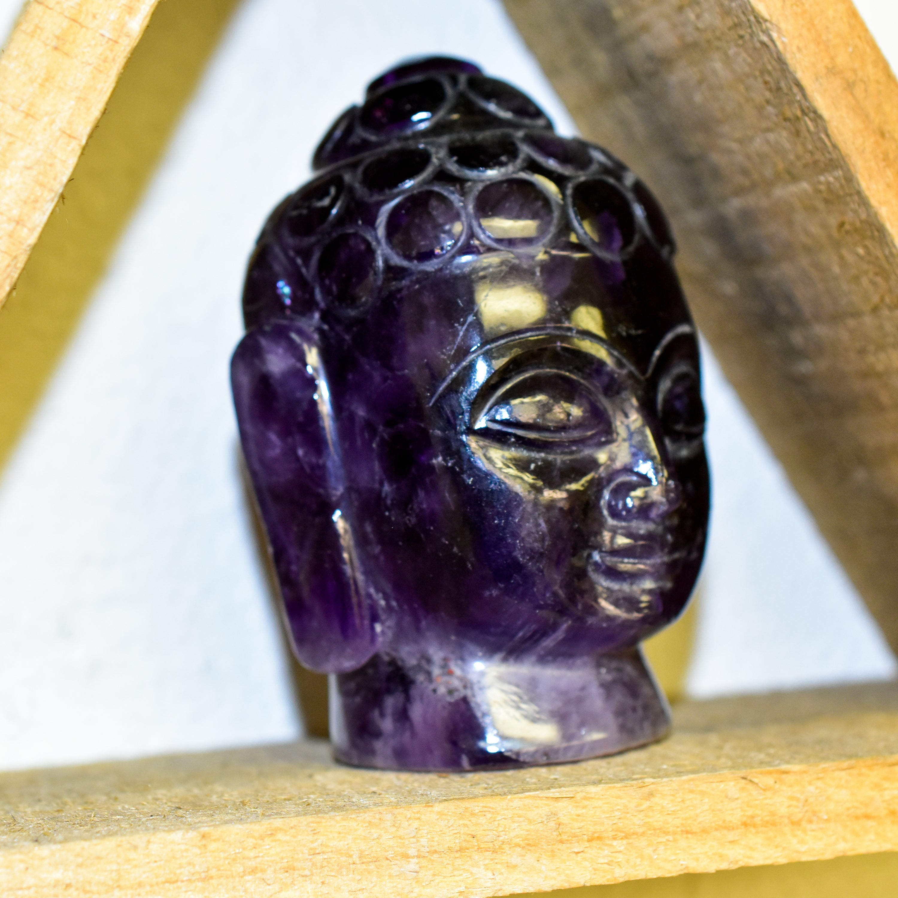 A stunning Crystal Buddha Head made from grade A Amethyst and Clear Quartz, showcasing deep purple and clear features, perfect for home decor.