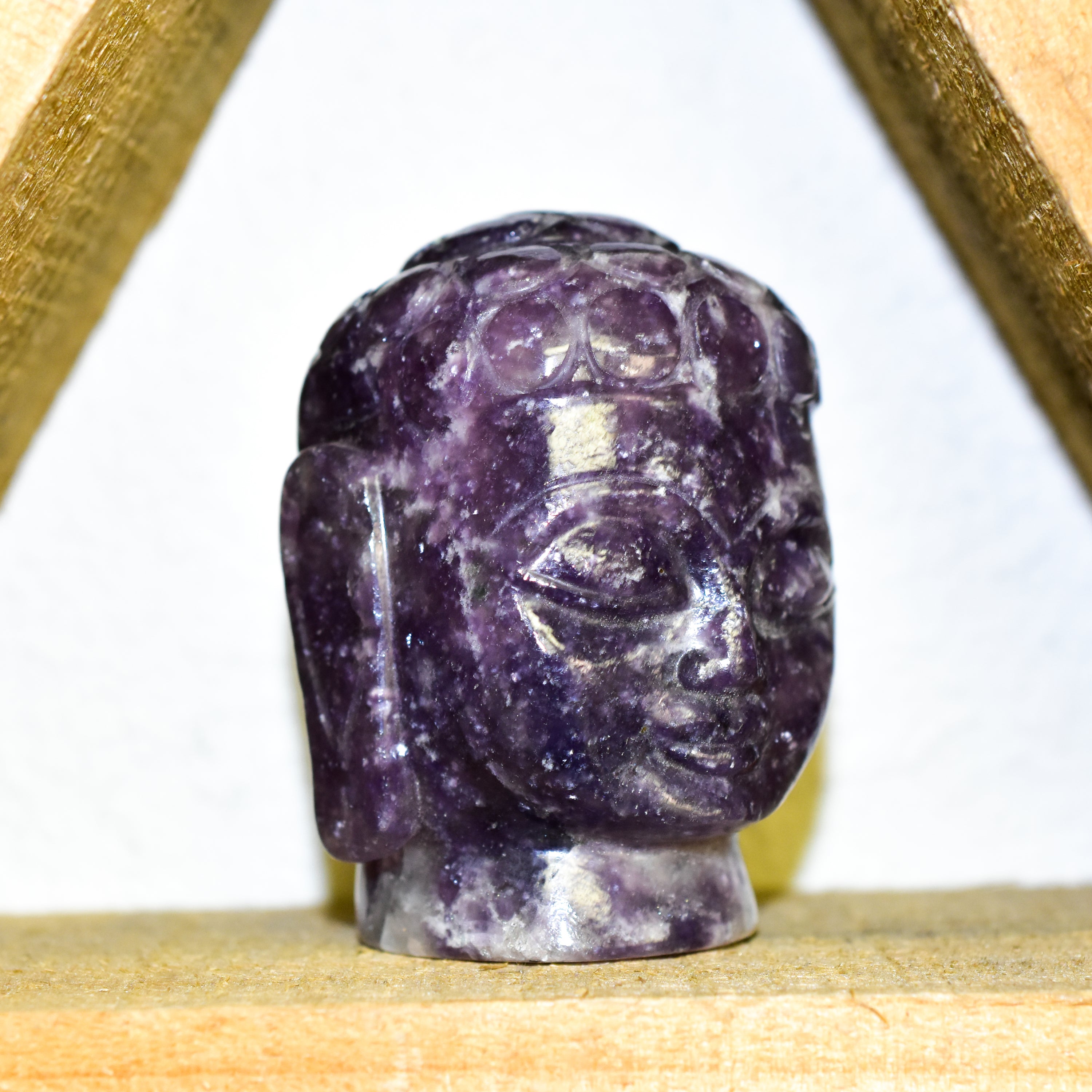 A stunning Crystal Buddha Head made from grade A Amethyst and Clear Quartz, showcasing deep purple and clear features, perfect for home decor.