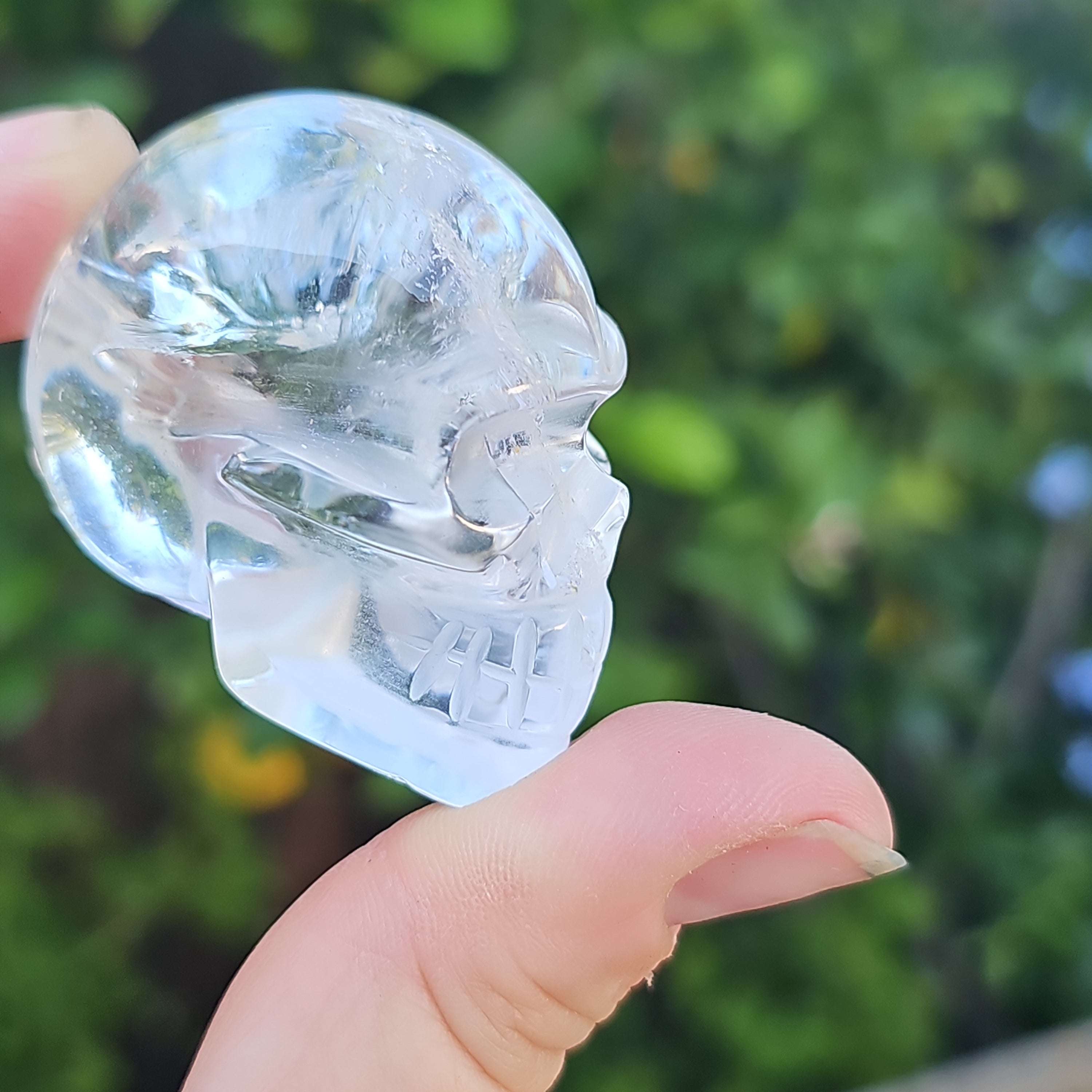 A beautifully handcrafted crystal skull made from high clarity quartz and amethyst, showcasing intricate details and vibrant colors.